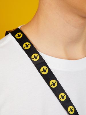  Closeup of Person on a yellow background wearing a white t-shirt and a black lanyard with the yellow "Please give me space" symbol.