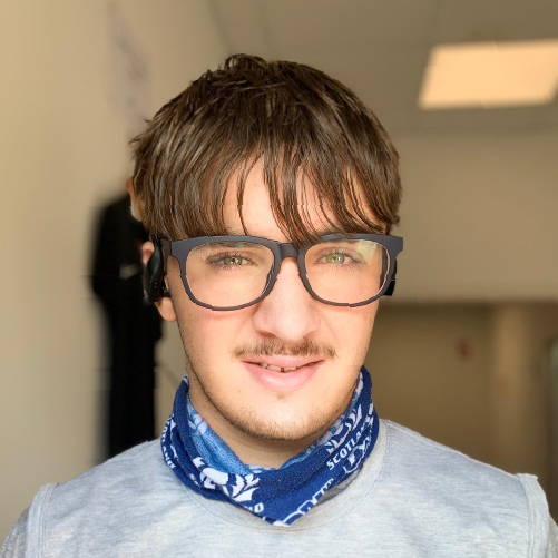 Photo of Khovan, brown hair, smiling wearing black framed glasses and a blue bandana around his neck.