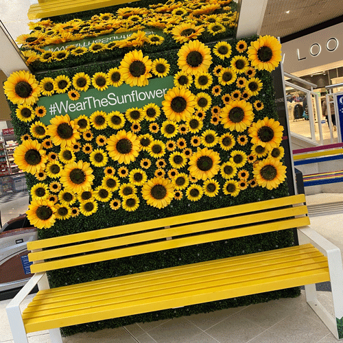 Wall of sunflowers with sign saying wear the sunflower