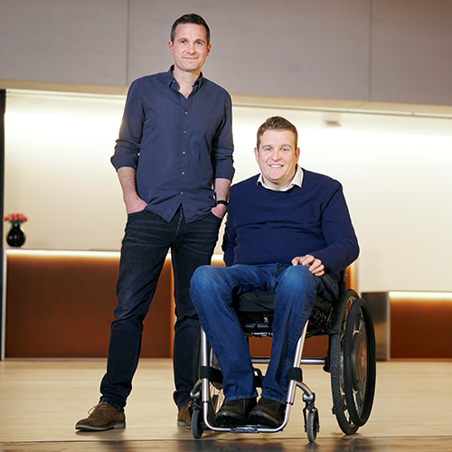 Portrait of man in wheelchair next to man standing 